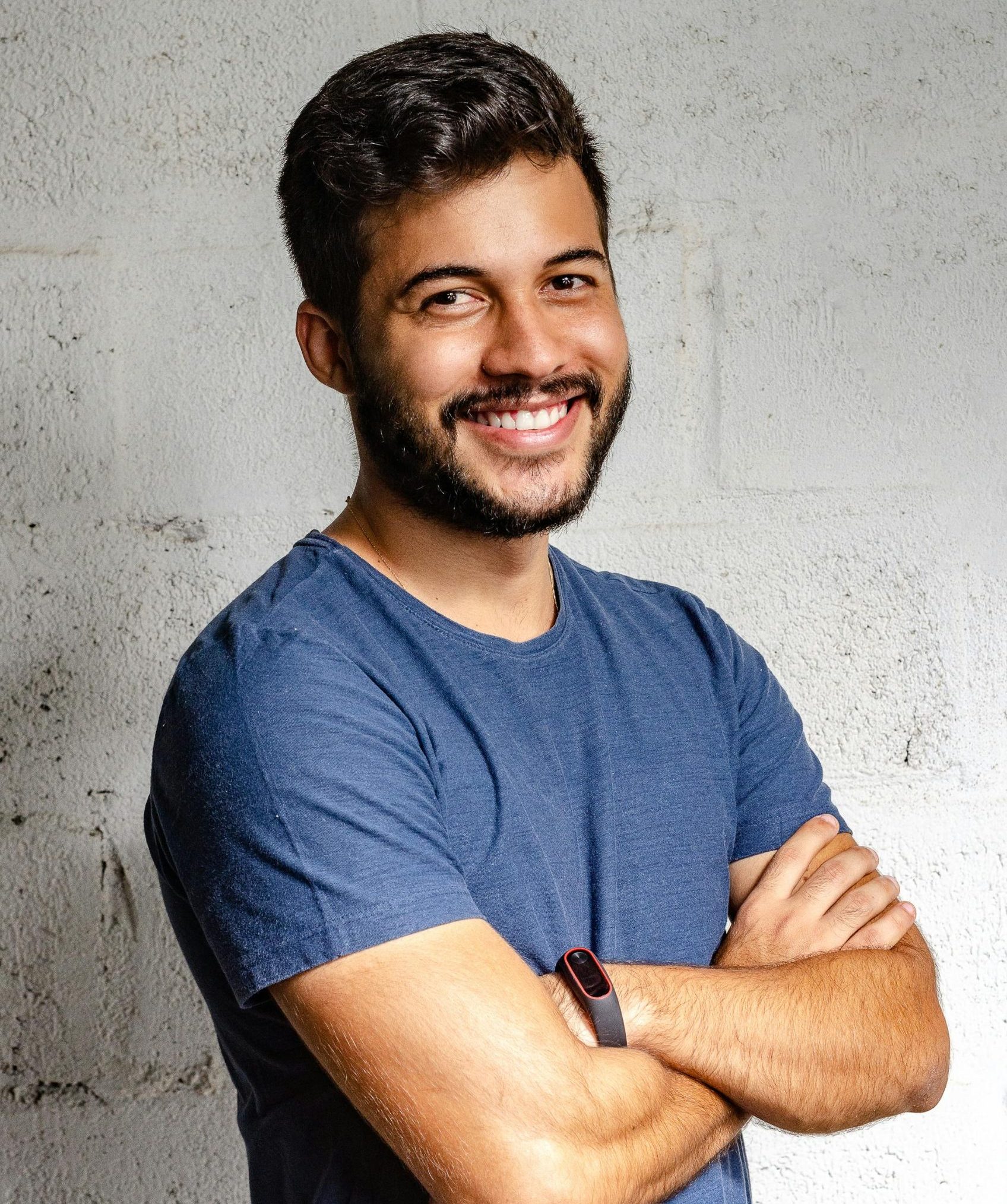 Portrait of a happy man with arms crossed, exuding confidence and friendliness.